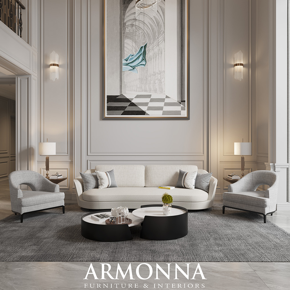 Elegant living room with a light gray sofa, two curved armchairs, and a large framed artwork centered on paneled walls, with round black-and-white coffee tables and a gray rug.