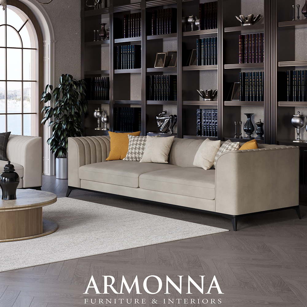 Modern living room with a beige sofa and multiple throw pillows in front of tall dark wood bookshelves, a round coffee table, and a potted plant.