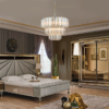 Luxurious master bedroom with a tufted gray bed gold trimmed mirrors and a crystal chandelier