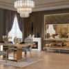 Luxurious dining room with a gold edged glass table four gray tufted chairs and a crystal chandelier