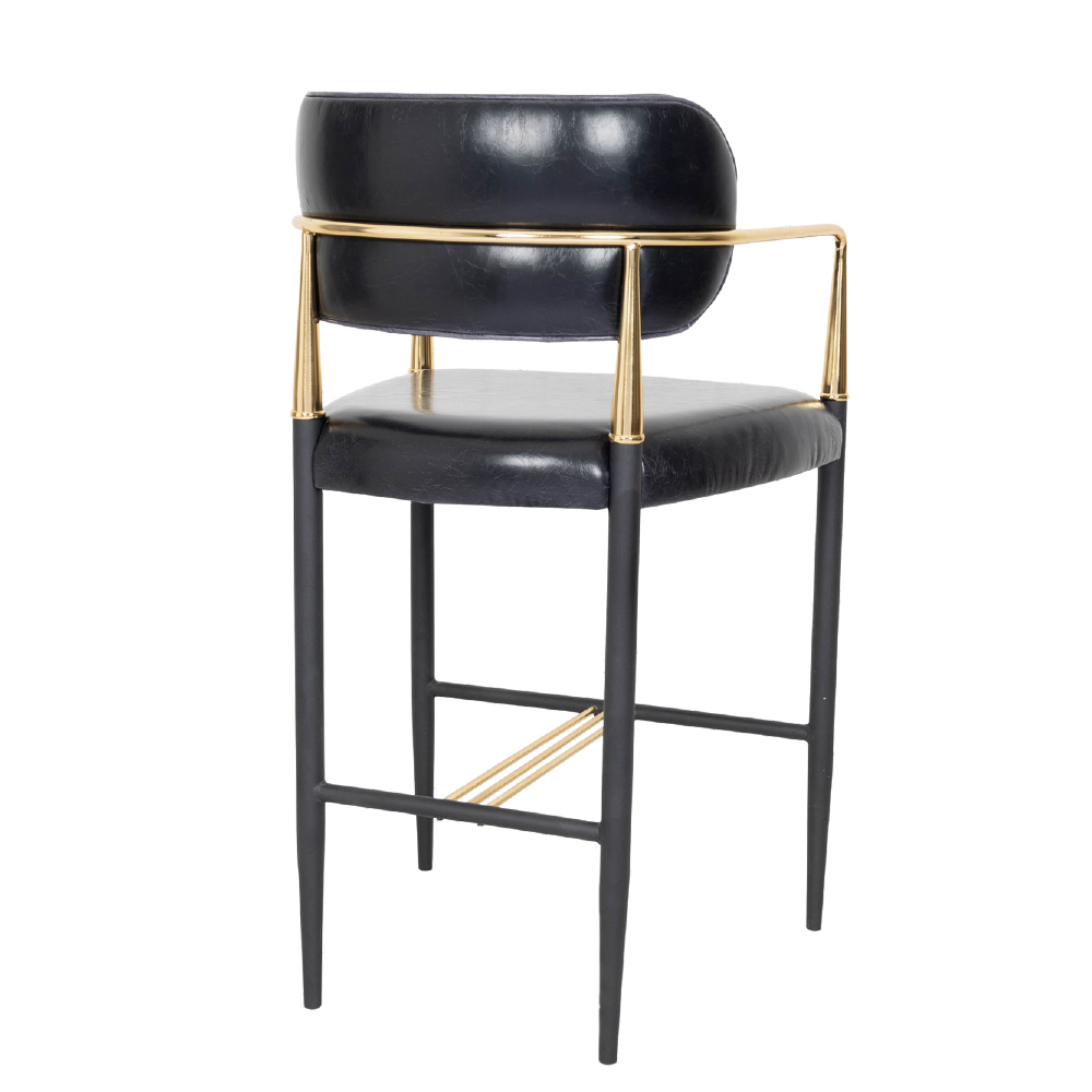 Black leather bar stool with a gold metal frame and footrest, standing on slender black legs.