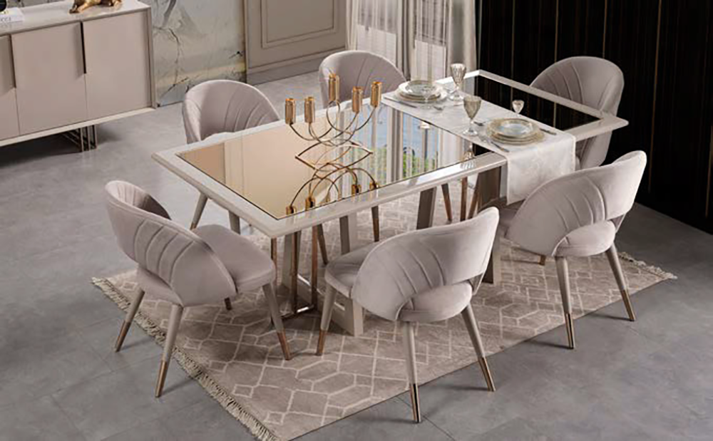 Elegant dining room scene with a glass-top table, six upholstered cream chairs, and place settings on a patterned rug.