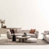 Modern living room with light beige curved sofas brown cushions a circular coffee table and a neutral rug