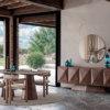 Modern dining room with a round wooden table and six upholstered chairs large glass doors and a geometric patterned sideboard with blue decor