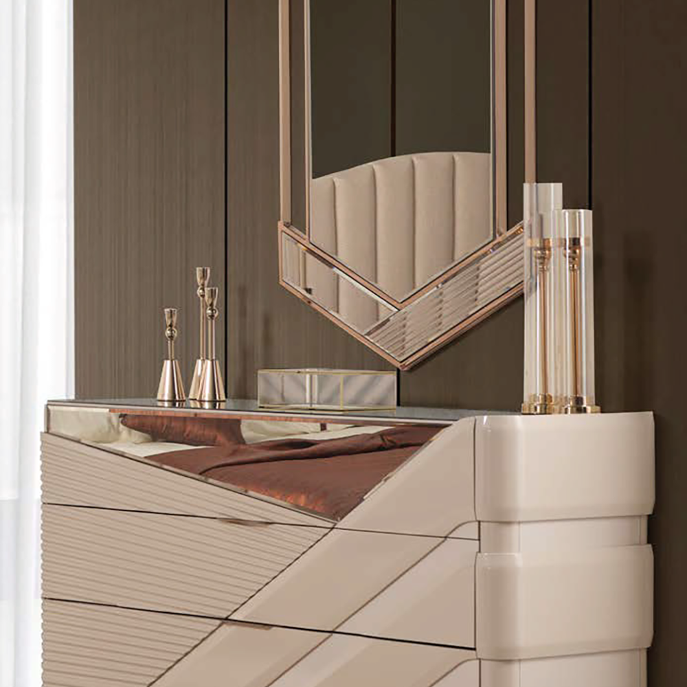 Italian-inspired vanity with a geometric white dresser, rose-gold mirror, and glass accessories in a dark wood room.