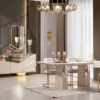 Luxurious modern dining room with a glass topped table white upholstered chairs and a mirrored sideboard under a chandelier