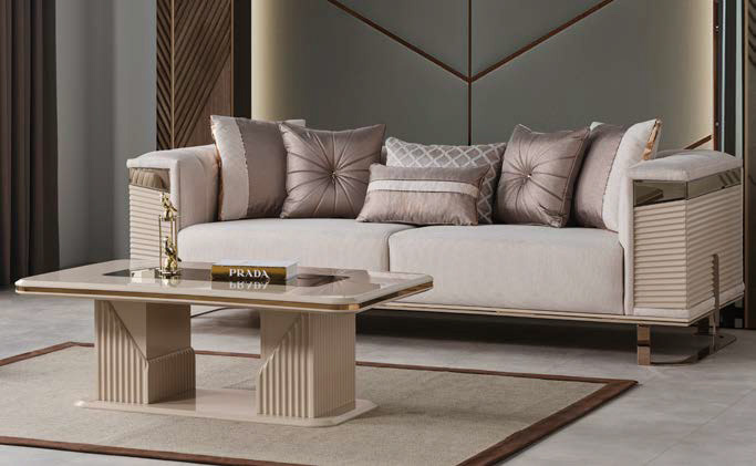 Luxurious living room scene with a beige sectional sofa and multiple taupe pillows a matching beige coffee table and a Prada book on top