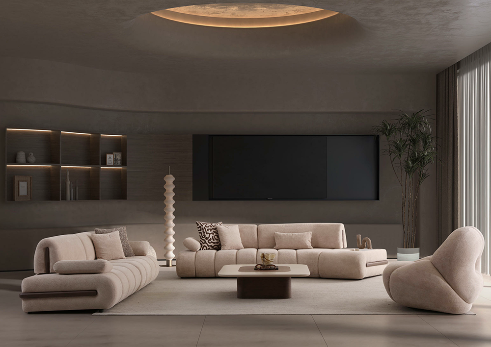 Modern beige living room with curved sofas, a low coffee table, and a large wall-mounted TV, plus a shelving unit and tall floor lamp.