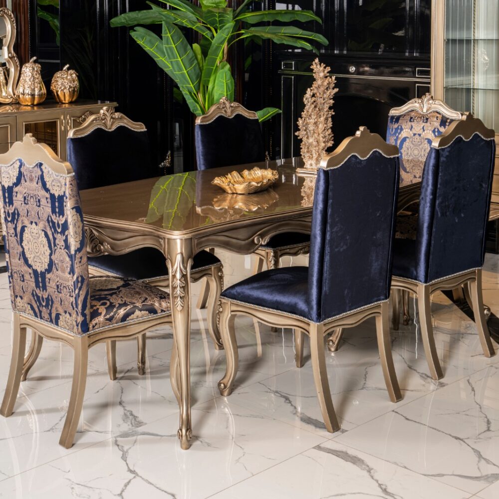 Luxurious dining room with a gold-carved table and blue velvet chairs on a marble floor.