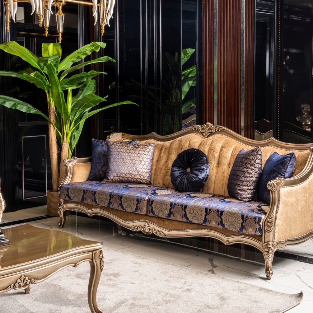 Luxurious living room with a gold-framed cream sofa, blue patterned upholstery and matching cushions in a dark glossy room.