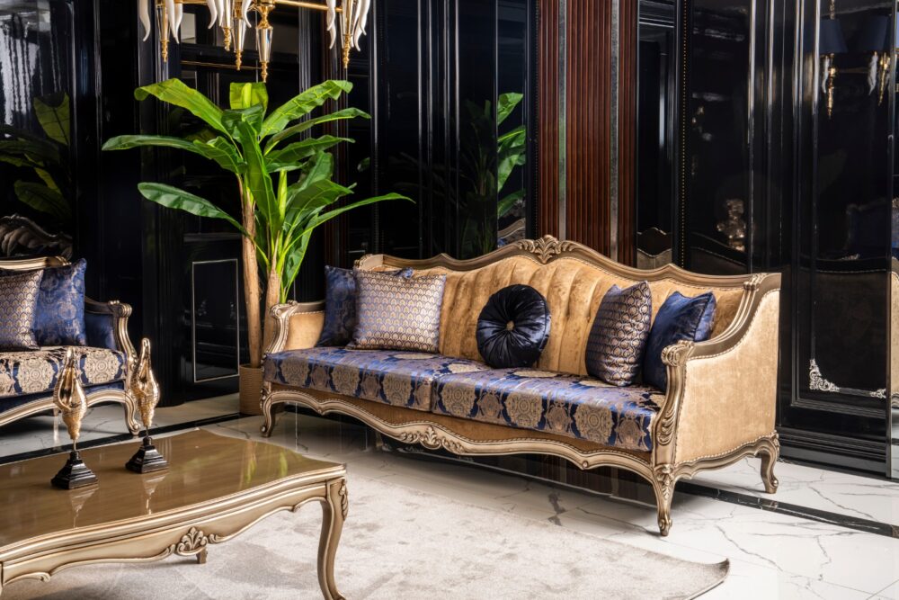 Emirgan Classic Set 28 Armonna Luxurious living room with a gold framed cream sofa blue patterned upholstery and matching cushions in a dark glossy room