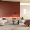 Fin Corner Set 1 Armonna Modern living room with a curved off white sectional sofa rust accent wall and round coffee tables on a light rug