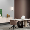 Modern dining room with a white rectangular table six brown upholstered chairs and a beige sideboard against gray walls with a wall light above