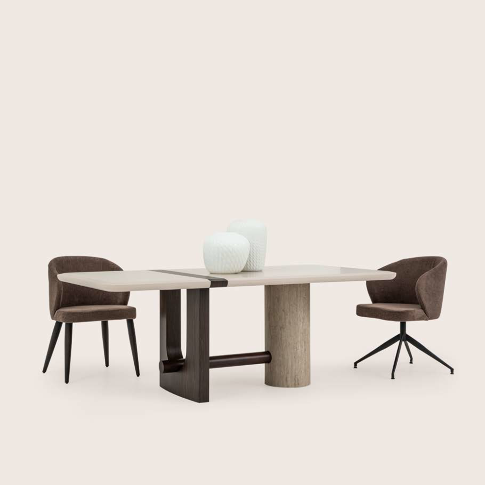 Rectangular dining table with two brown upholstered chairs on a pale background, with three white vases on the tabletop.