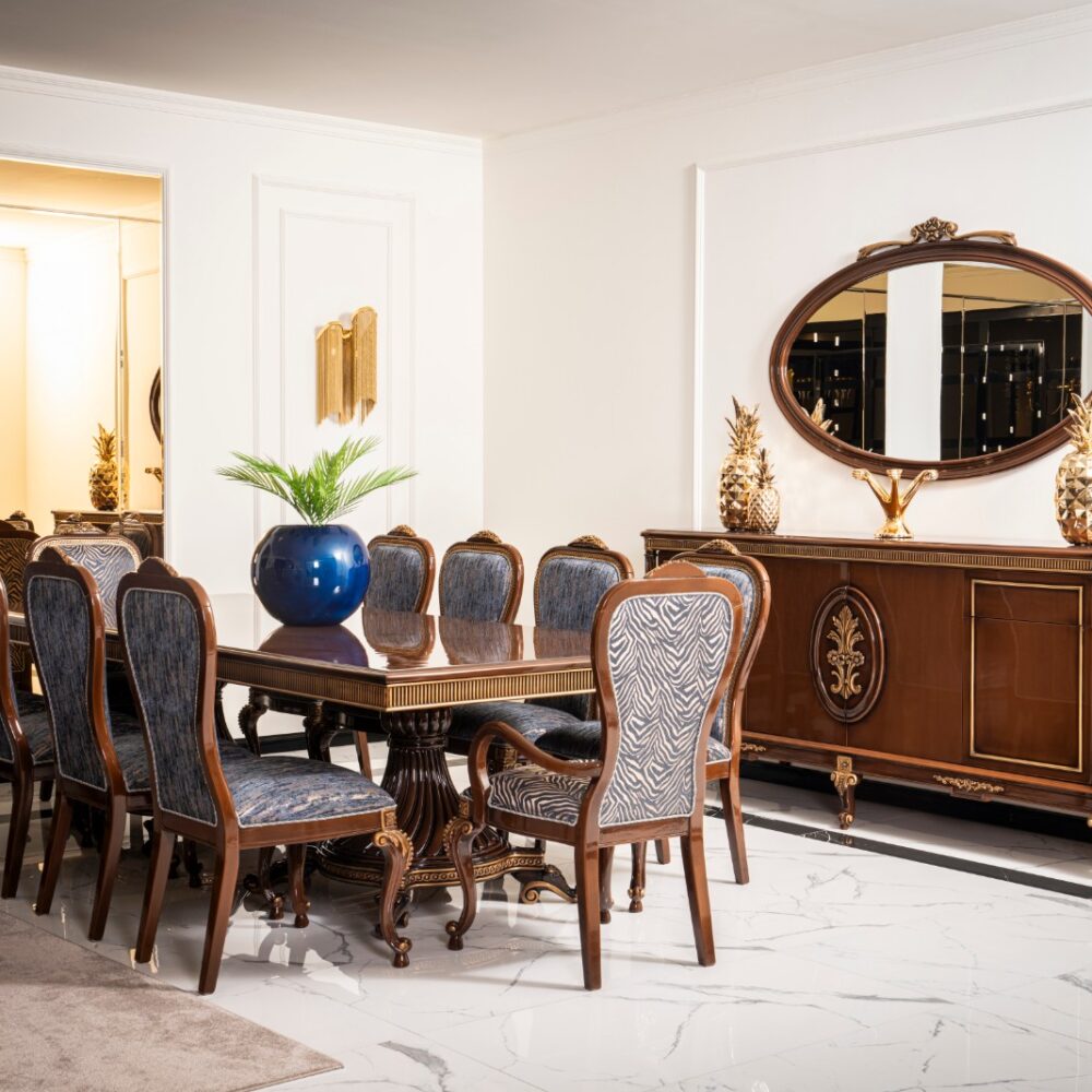 Elegant dining room with a dark wood table, upholstered blue chairs, and a sideboard topped by an oval mirror and gold pineapple accents on marble floors?