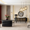 Elegant living room with a glossy black curved dining table cream chairs a sideboard round mirror and gold pendant lights above