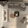 Top down view of a modern living room with a gray L shaped sectional a beige sofa two coffee tables on a textured rug and floor to ceiling windows with curtains