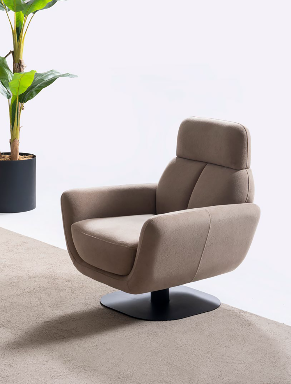 Liberta Living Room 4 Armonna Beige upholstered swivel lounge chair on a black circular pedestal base beside a potted plant in a bright minimal room