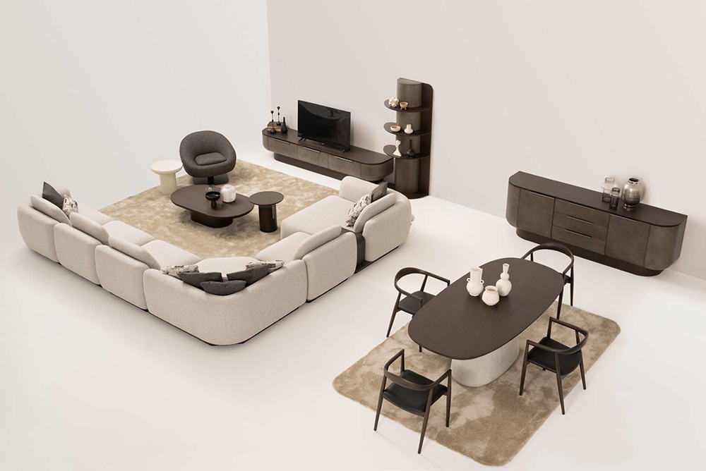 Living room with a beige sectional sofa around a round coffee table, a gray accent chair, and a media wall with a TV, plus a dark wood dining table and six chairs on a beige rug.