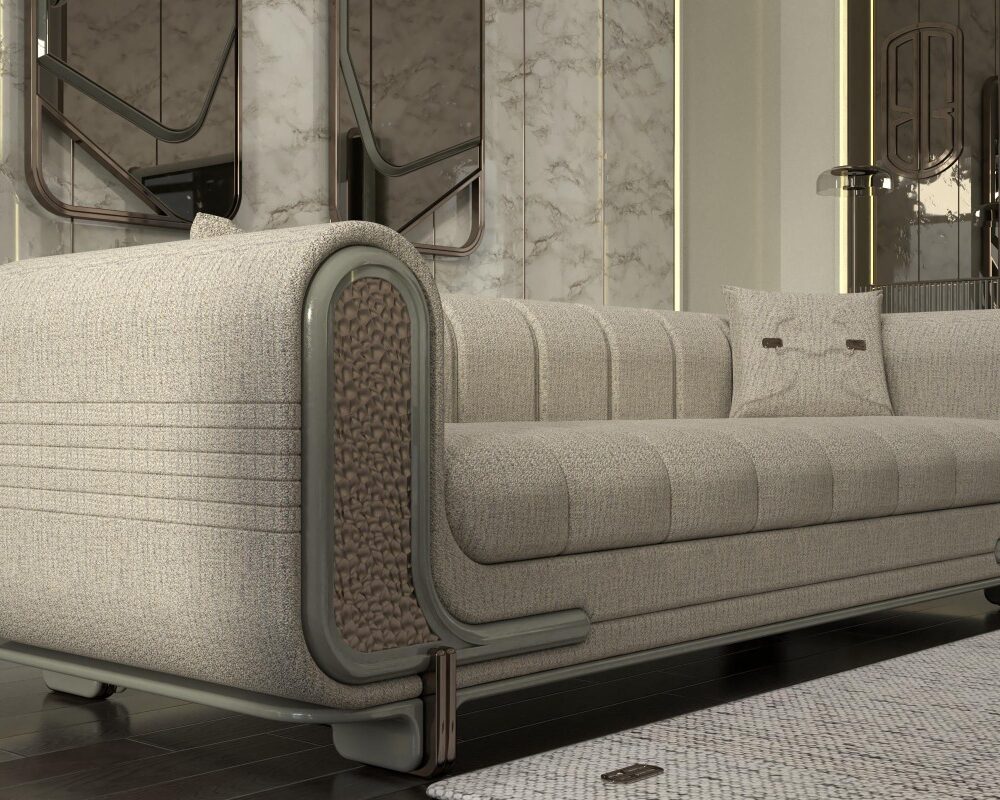 Luxurious beige upholstered sofa with rounded arms and metal trim in a marble-clad lobby space.