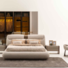 Modern bedroom with a plush low profile bed matching nightstands and a large glass front wardrobe in beige tones