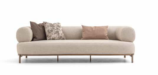 Beige modern sofa with rounded arms and four pillows in varying colors on a white background.