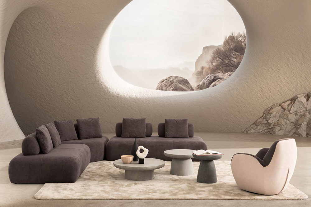 Marshmallow Corner Set2 Armonna Modern living room with a circular window in a beige cave like wall a dark sectional sofa and round coffee tables