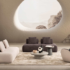 Marshmallow Corner Set4 Armonna Modern living room with curved beige sofa dark lounge round coffee table and a large oval window showing a rocky mountain landscape