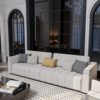 Modern living room featuring a light gray sectional sofa with mixed cushions a glass partition wall and a coffee table with an open book