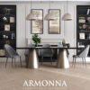 Modern dining room with a black glass table on gold cone bases six gray upholstered chairs and beige pendant lights above