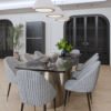 Modern dining room with a marble topped oval table grey ribbed chairs a brass pedestal base pendant lights and black arched cabinets with plants nearby