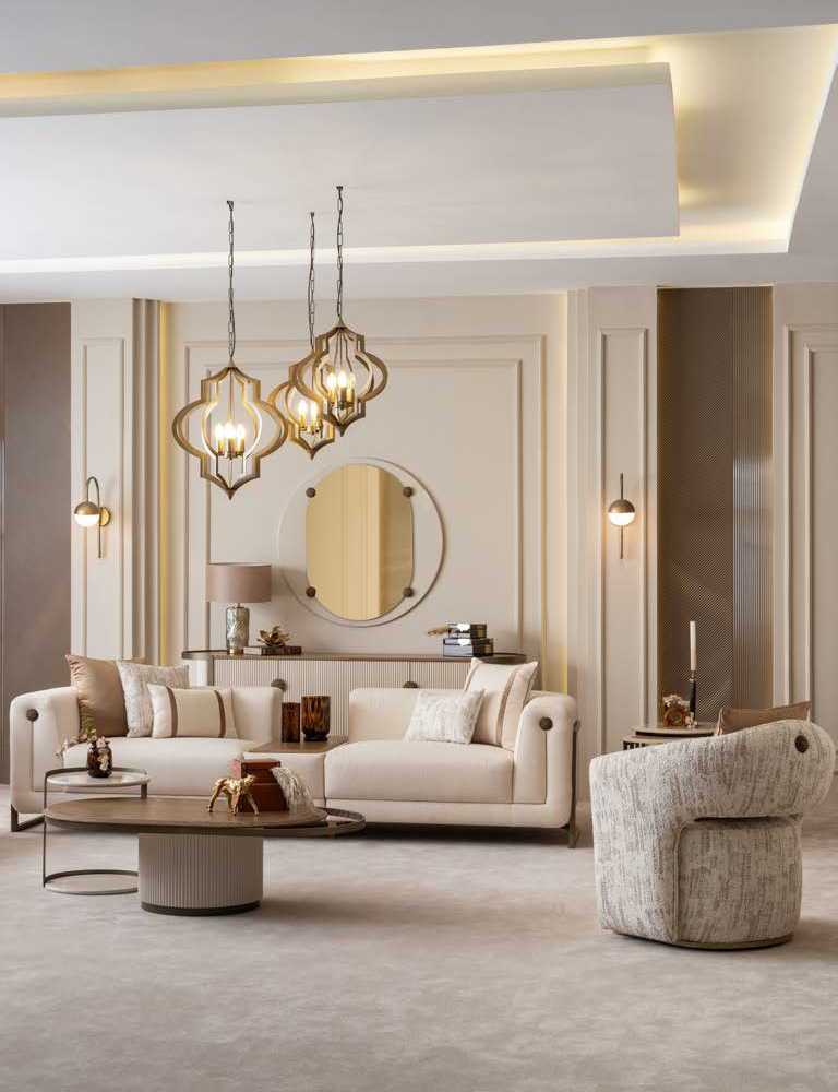 Elegant living room with cream sofas, round wall mirror, and three geometric pendant lights in warm tones.