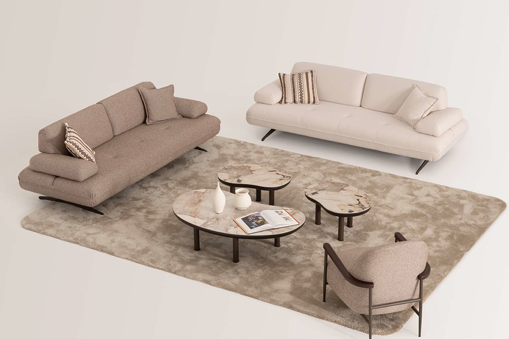 Living room with two beige sofas, a cream armchair, and four round marble-topped coffee tables on a light rug.