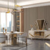 Mustang Dining Room and TV Unit 1 Armonna Luxurious dining room with a gold accented round table gray upholstered chairs and a mirrored sideboard against paneled walls in soft lighting