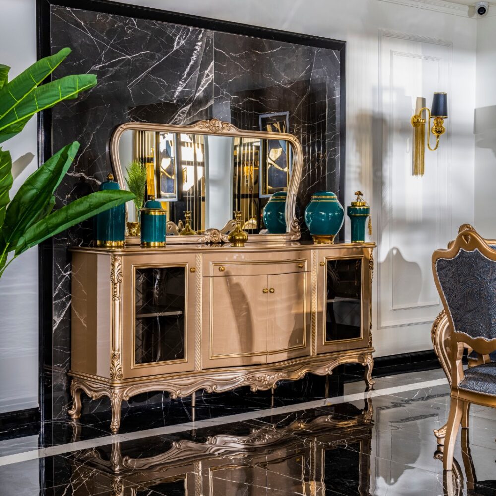 Ornate gold sideboard with a large mirror, teal vases, and decorative items against a black marble backdrop.