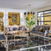 Napoli Classic Set 3 Armonna Luxurious living room with ornate gold framed sofas blue and blush cushions and a gold chandelier on a black marble floor