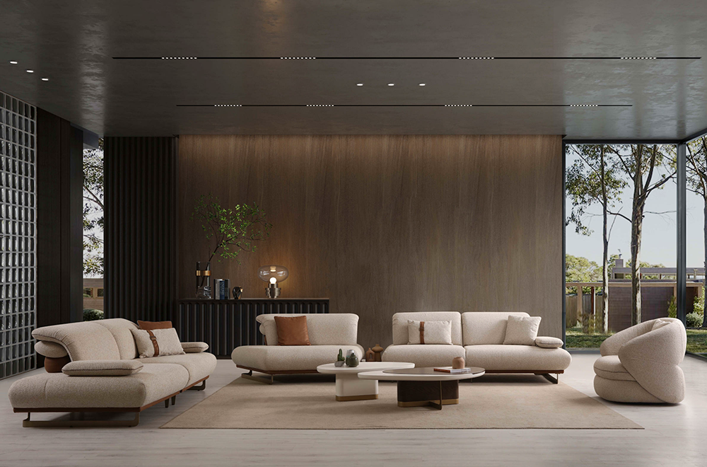 Modern living room with three beige sectionals arranged around a circular coffee table and neutral rug, large glass walls reveal outdoor trees and patio area in the background.