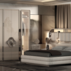 Luxurious modern bedroom with a large upholstered bed and mirrored wardrobe cabinets Ends of the bed have built in lamps and round nightstands with a window view outside