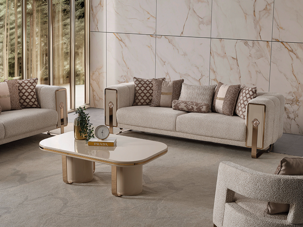 Neva Living Room 3 Armonna Luxurious living room with beige sofas patterned cushions a white glossy coffee table and a marble paneled wall on a sunlit backdrop