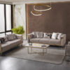 Luxurious modern living room with two beige velvet sofas a matching armchair gold metal frames and a glass coffee table in a sunlit space