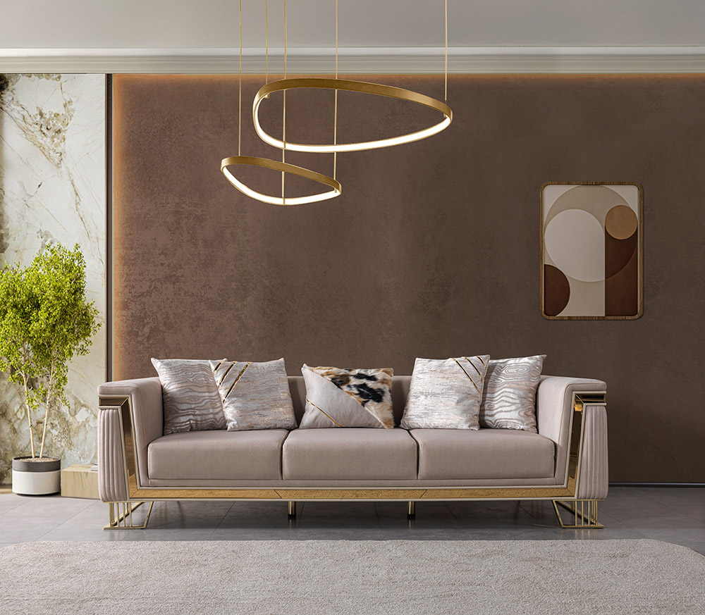 Nisan Living Room 13 Armonna Elegant beige sofa with gold accents against a brown textured wall in a modern living room with circular pendant lights overhead and abstract wall art to the right