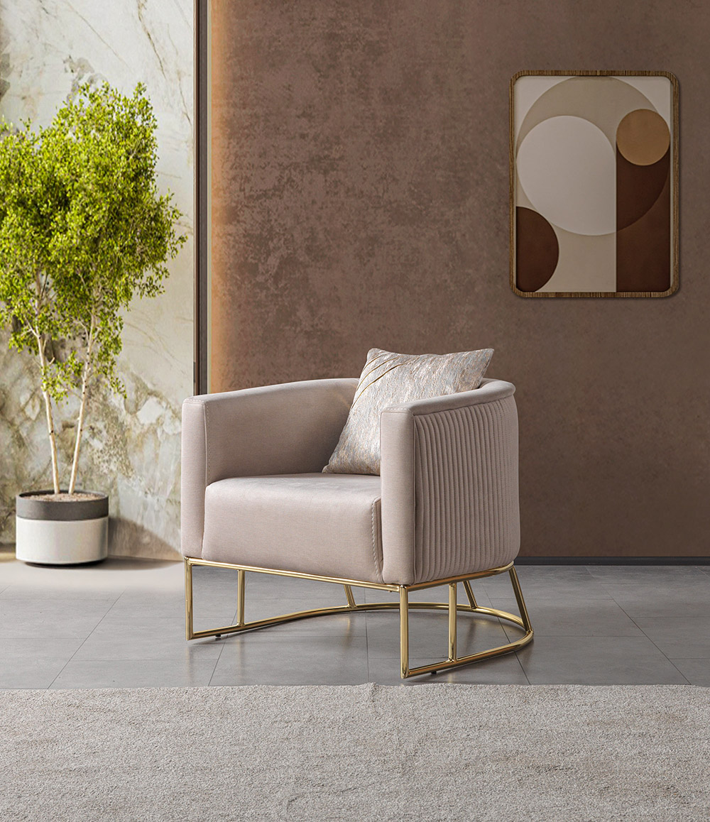 Nisan Living Room 14 Armonna Beige upholstered armchair with a gold metal base in a modern living room next to a potted plant and abstract wall art
