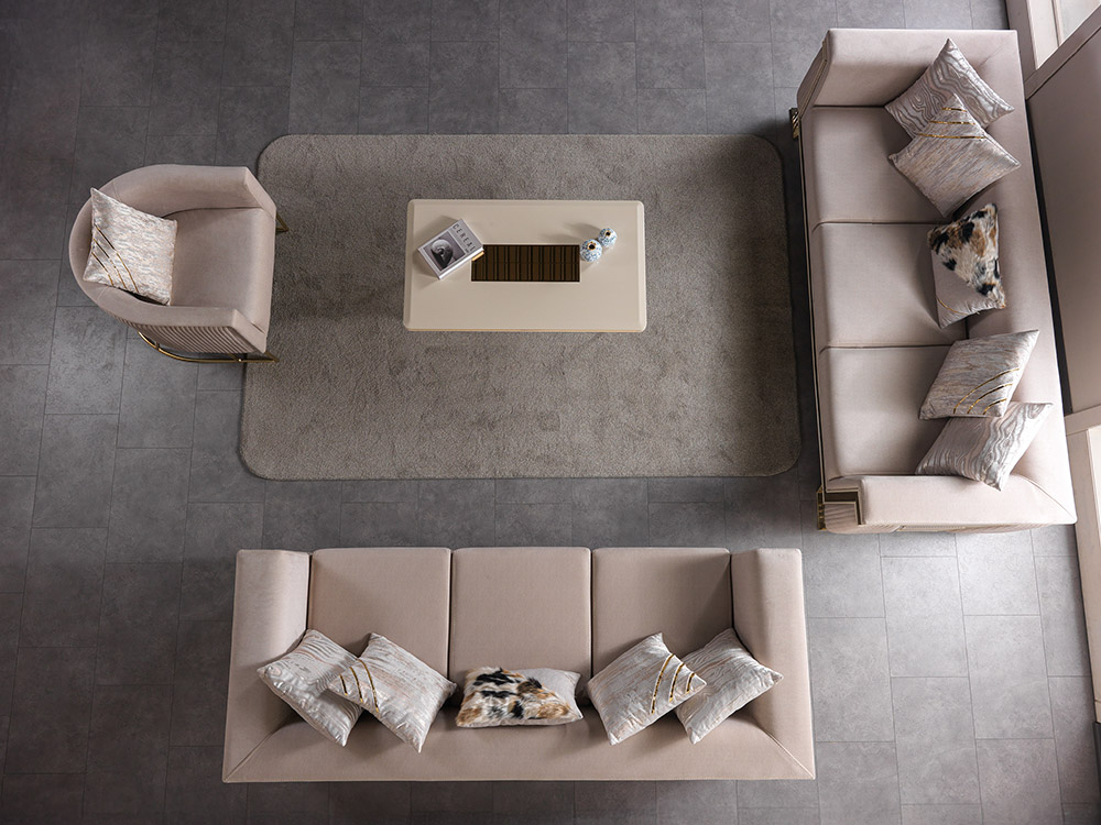 Nisan Living Room 7 Armonna Top down view of a beige living room with three sofas around a central coffee table on a gray tiled floor with decorative cushions