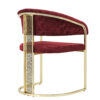Luxurious burgundy velvet chair with a gold metal frame and decorative pierced side panel