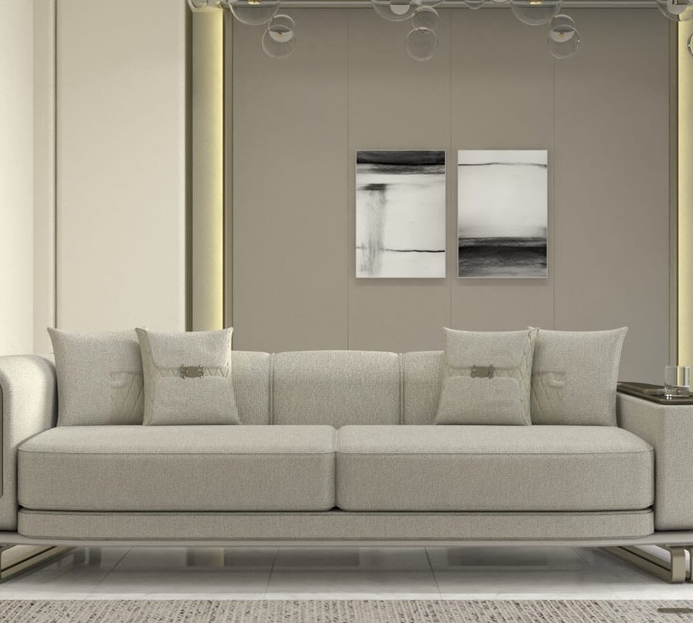 Modern light gray sofa with rounded arms and metal base in a bright showroom; two abstract black-and-white paintings on a taupe wall behind.