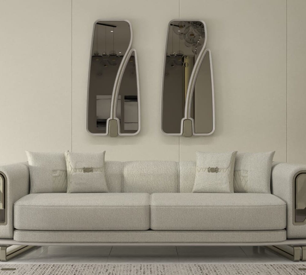 Modern beige sofa with rounded arms in a minimalist living room, with two tall wall mirrors above and a potted plant nearby.