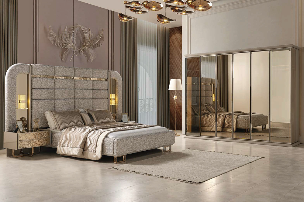 Luxurious modern bedroom with a padded upholstered bed, mirrored wardrobe, and soft beige decor.