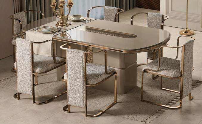 Luxurious dining room set with a glass-top table, brass frame, six upholstered chairs, and a candelabra centerpiece.