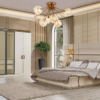 Luxurious modern bedroom featuring a large upholstered bed with matching headboard two nightstands and a gold accent chandelier above A tall wardrobe potted plant and large window with sheer curtains anchor the space