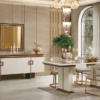 Luxurious dining room with a white and gold sideboard a chandelier and a marble topped table set for a formal meal near a large arched window
